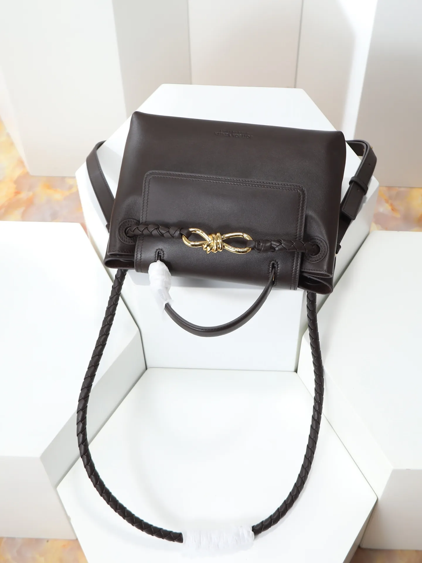 1150. Bottega Veneta's latest Ciao Ciao bag is a two-way flap handbag in silky cowhide, decorated with signature twist details, hidden hook closure, the flap can be fastened to the front, or connected to the INTRECCIATO woven internal pocket, with an adjustable and removable crossbody strap, an internal compartment, and a zippered pocket. The surprise flap has various shapes. Style 1 - Cover the bag surface, exposing the knot and knot decoration. Style 2 - Place the flap inside the bag. A buckle is also designed. Style 3 - The U-shaped position of the top handle in the hand bag. Style No.: 835835 Size: 26*19*10.5cm